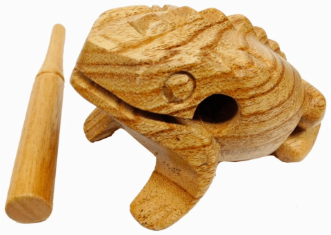 A wooden scraper carved to look like a frog with a stick beside it