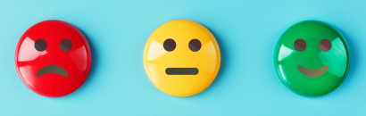 Sad face, neutral face, and happy face pins on a blue background